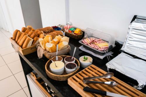 a table with baskets of bread and pastries on it at Praia Comprida Hotel in São José