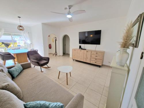 a living room with a couch and a flat screen tv at Apartment Oasis Park AL in Portimão