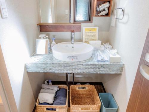 a bathroom with a sink and a counter with baskets at Riverside Glamping Kamiseno - Vacation STAY 92757v in Hiroshima