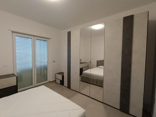 1 dormitorio con espejo y 1 cama. en Gocce di mare Sicilia en Rometta Marea