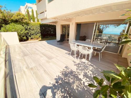 une terrasse en bois avec une table et des chaises sur une maison dans l'établissement Absolute calm, modern, terrasse, garden & pool, au Cannet