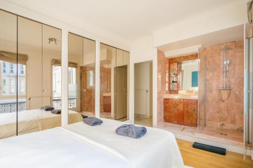 - une chambre avec 2 lits et une douche dans l'établissement Appartement Tour Eiffel & Trocadéro, à Paris