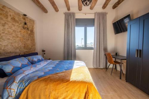 een slaapkamer met een bed, een bureau en een raam bij Radiant 5 BR family home with jacuzzi + roof deck in Palau de Santa Eulalia