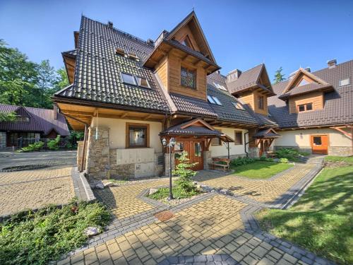 duży dom z dachem naczółkowym w obiekcie VisitZakopane - Tetmajera Apartment w Zakopanem