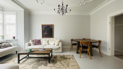 a living room with a couch and a table at ApartmentInCopenhagen Apartment 1599 in Hellerup