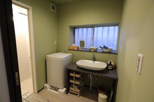 a bathroom with a sink and a toilet and a window at iko terrace - Vacation STAY 03195v in Kagoshima