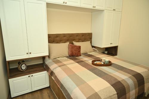a bedroom with a bed with a tray of food on it at Апартамент в топ центъра на Велико Търново in Veliko Tŭrnovo