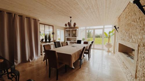 une salle à manger avec une table et une cheminée dans l'établissement Gite de Saint Florent - Piscine & Spa, à La Charrière