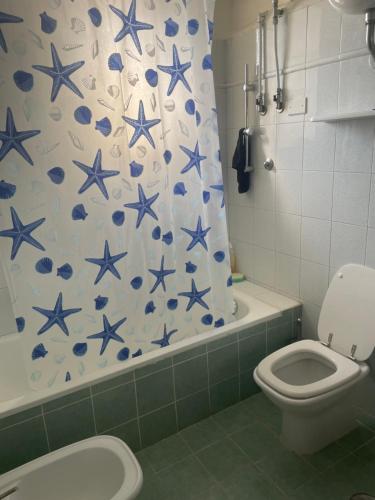 baño con aseo y cortina de ducha con estrellas azules en Villa sul mare, en Lido dei Pini