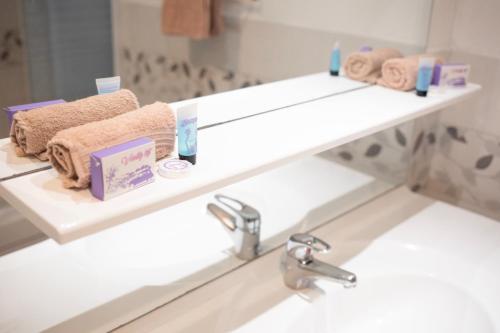 a bathroom with a sink with towels and a mirror at ++++ CENTRAL COSY DUPLEX ++++ A 5 MIN DES REMPARTS ET 12 MIN DE PLACE DALTON A PIEDS in Boulogne-sur-Mer