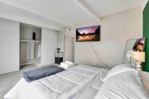 a bedroom with a large bed and a tv on the wall at North Pomona Home Near Claremont Colleges in Pomona