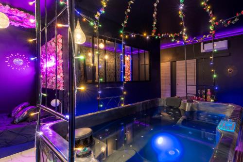 a jacuzzi tub in a room with christmas lights at Sweet SECRET'S JACUZZI in Le Breuil