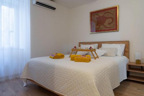 ein Schlafzimmer mit einem Bett mit gelben Kissen darauf in der Unterkunft San Teodoro in Split