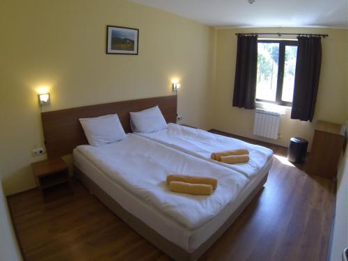 a bedroom with a large bed with two towels on it at Rusaliite Adventure House in Bachevo