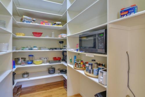 a walk in pantry with white shelves and a microwave at Close to Hot Springs Chalk Creek Meadows Home! in Nathrop