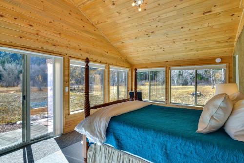 a bedroom in a log cabin with a bed and windows at Colorado Mountain Getaway about 12 Mi to Buena Vista! in Nathrop