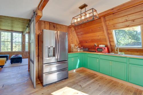 a kitchen with green cabinets and a stainless steel refrigerator at Pocono Getaway A frame Cabin w/ Hot Tub Sauna in East Stroudsburg