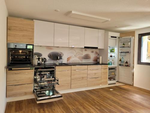 a large kitchen with white cabinets and appliances at 3.5-Zimmer FeWo Primeli Fieschertal in Fieschertal