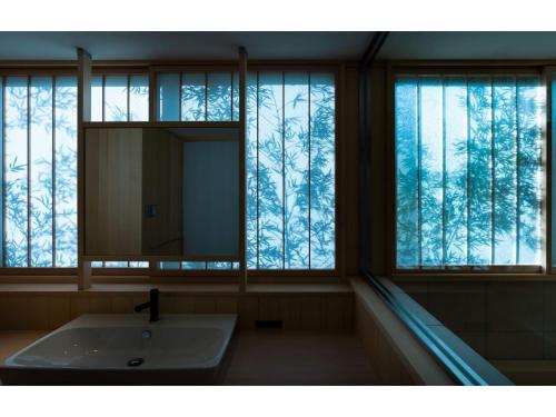 baño con espejo, lavabo y ventanas en THE JUNEI HOTEL KYOTO - Vacation STAY 14465v, en Kioto