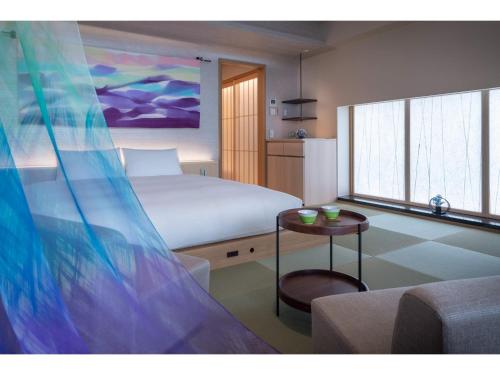 1 dormitorio con 1 cama y 1 mesa en una habitación en THE JUNEI HOTEL KYOTO - Vacation STAY 14465v, en Kioto
