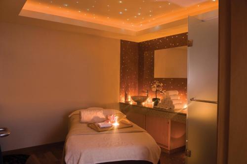 a bedroom with a bed with a candle on it at Constantinou Bros Asimina Suites Hotel in Paphos City