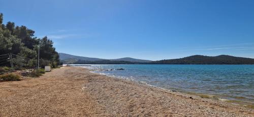 a beach with water and mountains in the background at Sunset Apartman Ana in Zaboric