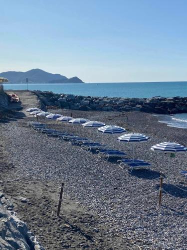 a row of umbrellas on a rocky beach at Villa Smeralda - Luxury on the Italian Riviera in Lavagna
