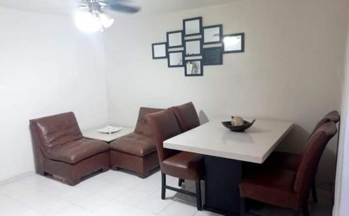 a room with a table and chairs and a table and a chair at Apartamento Las Flores Mérida in Mérida