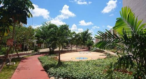 park z ścieżką i drzewami oraz budynek w obiekcie Apartamento Las Flores Mérida w mieście Mérida