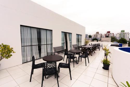 a patio with tables and chairs on a roof at Praia Comprida Hotel in São José