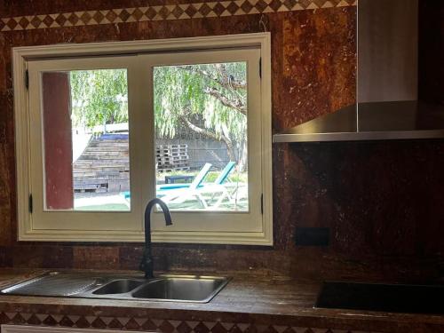 fregadero de cocina con ventana sobre una encimera de cocina en Casa de campo con piscina en Las Palmas de Gran Canaria