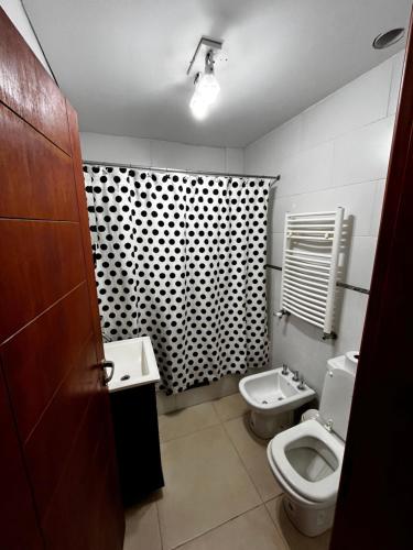 a bathroom with a toilet and a bidet and a sink at Alojamiento El Remanso in Olavarría