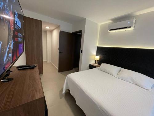 a bedroom with a bed and a flat screen tv at Apart. 1 Dorm Equipetrol Nanotec in Santa Cruz de la Sierra