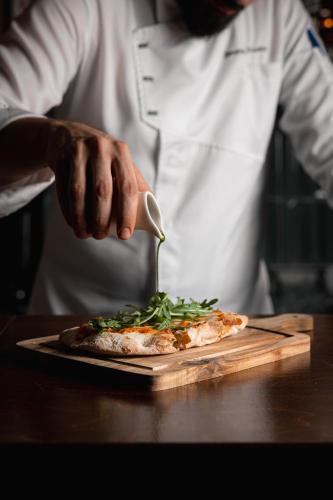 a chef is preparing a pizza on a cutting board at The Residence Aiolou Hotel & Spa in Athens