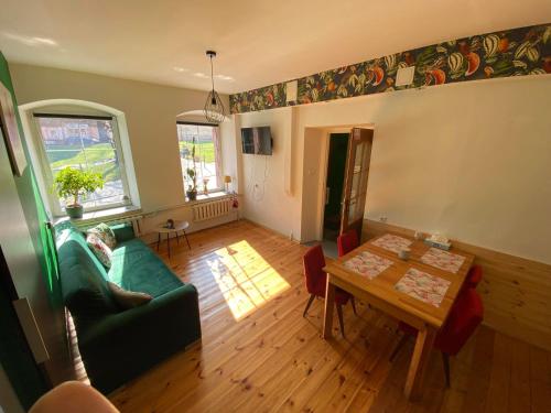 a living room with a green couch and a table at Pod Papugami in Srebrna Góra