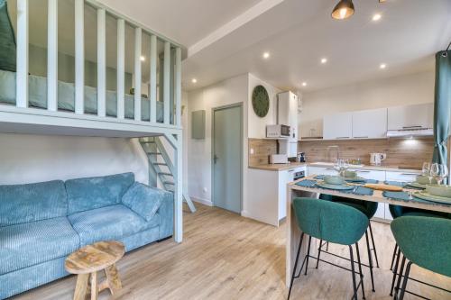 a living room with a blue couch and a loft bed at L'olivier Studio Lumineux avec agréable terrasse in Fécamp