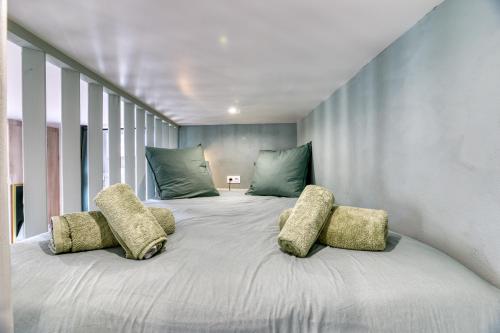 a bedroom with a large bed with four pillows at L'olivier Studio Lumineux avec agréable terrasse in Fécamp