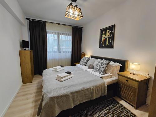 a bedroom with a large bed and a night stand at Mega Residence in Târgovişte