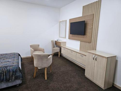 a hotel room with a bedroom with a tv and a bed at Naš Dom Hotel in Bijelo Polje