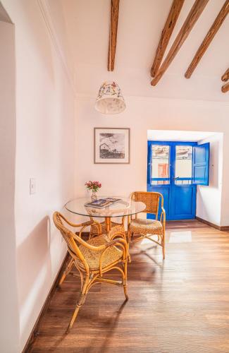 a dining room with a table and chairs and a blue door at Quinta San Blas by Ananay Hotels in Cusco