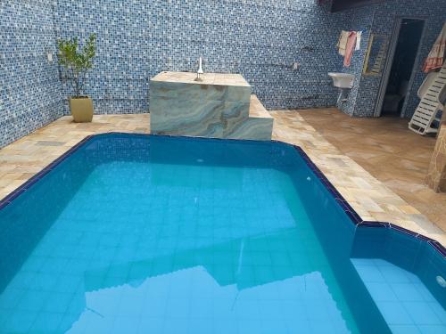 uma grande piscina azul numa casa de banho em Casa Mongagua em Mongaguá