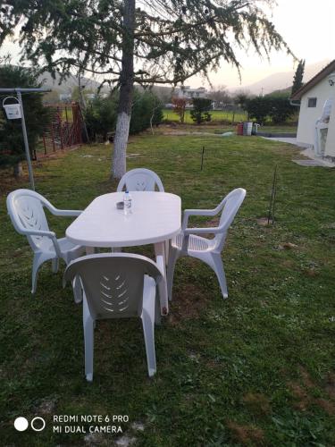 a white table and chairs in a yard at Kavala,Garden House in Kokkinókhoma