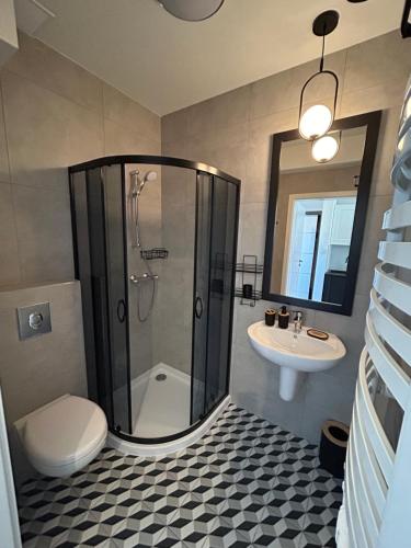 a bathroom with a shower and a toilet and a sink at Apartamenty Bellamaya - Kapitanska 8 in Grzybowo
