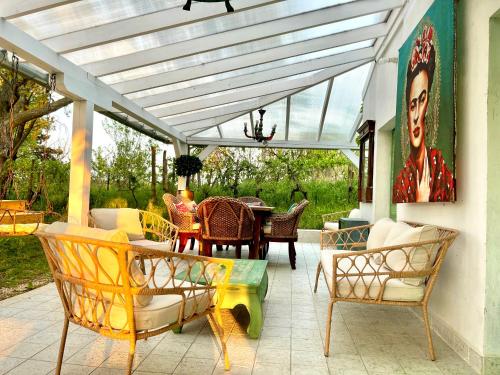 a conservatory with a table and chairs on a patio at Bohemian Eco lodge át lake Balaton in Kisapáti