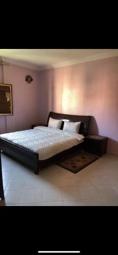 een slaapkamer met een groot bed met witte lakens en kussens bij Appartement lumineux et spacieux en plein centre ville in Ouarzazate