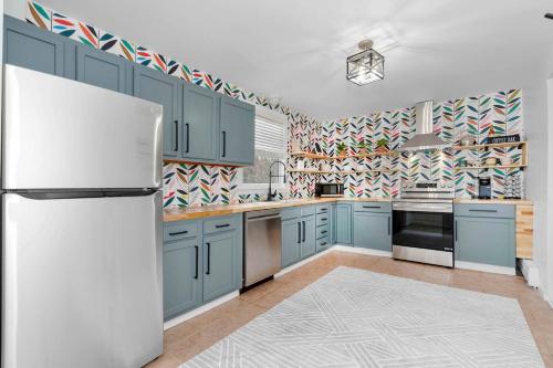 a kitchen with blue cabinets and a white refrigerator at White Clay Creek Cottage in Newark