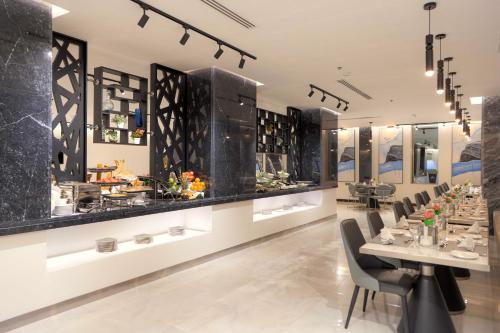 un restaurante con una mesa larga y sillas en فندق ساس - SAS Hotel en Hafr Al Batin