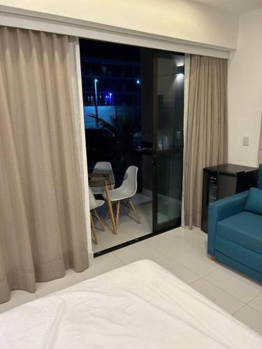 sala de estar con sofá azul y ventana en Makia - térreo Bloco C 011 - Churrasqueira top, en Porto de Galinhas