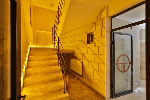 a staircase in a building with a yellow wall at Yellow Stone House in Goreme