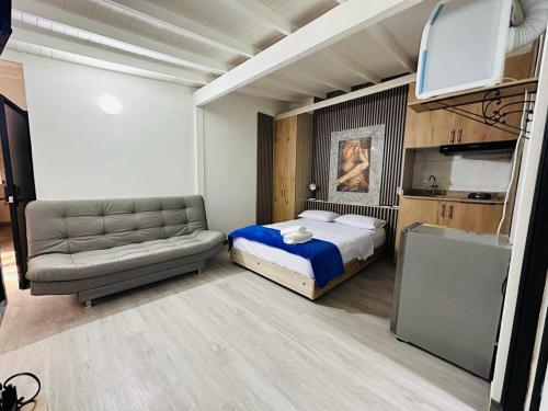 1 dormitorio con cama, sofá y TV en Hotel Lares 70 Laureles, en Medellín